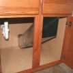 Custom made clothes chute in vanity cabinet hidden behind door.